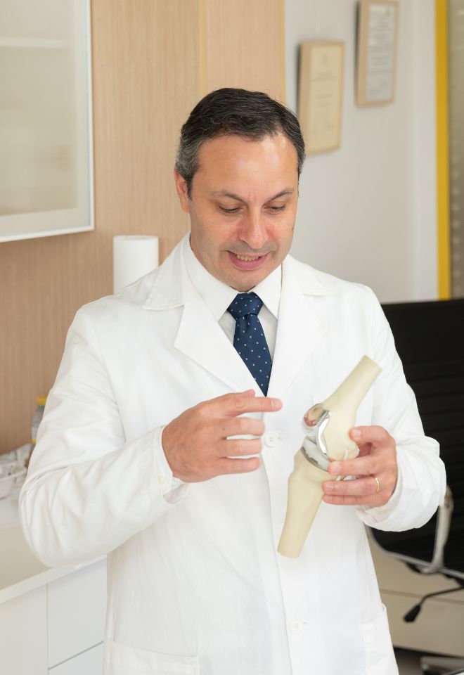 Traumatólogo en Marbella - Dr. Ignatius Chatziandreou explicando una prótesis de rodilla